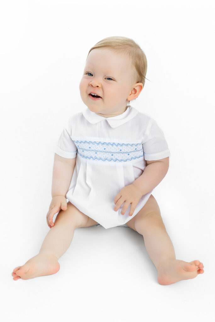 cake smash photoshoot NYC, baby boy Feltman Brothers smocked romper laughing, Heirloom by Melissa