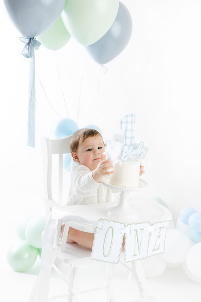 first birthday photography cake smash, baby boy blue green balloon garland, Heirloom by Melissa Flatiron
Image