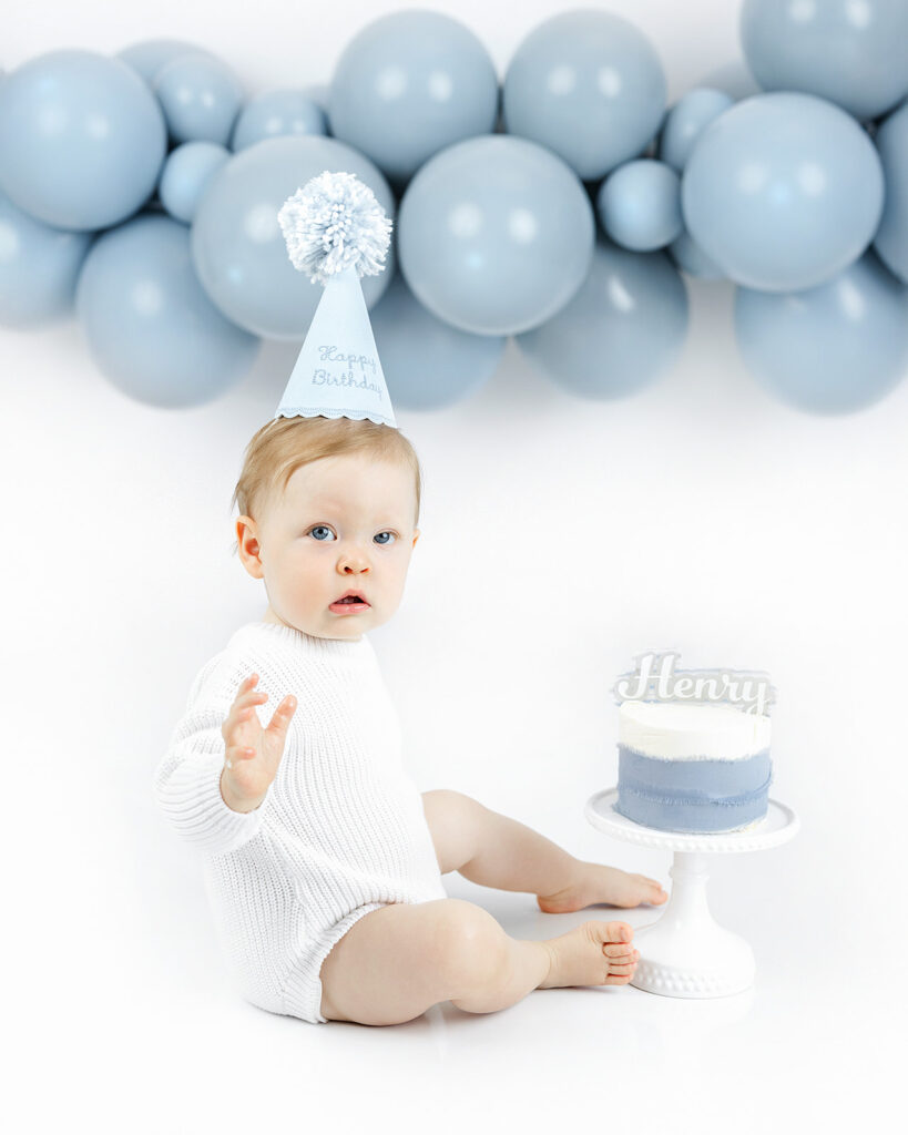 cake smash photoshoot NYC, baby boy laughing next to first birthday cake, Heirloom by Melissa