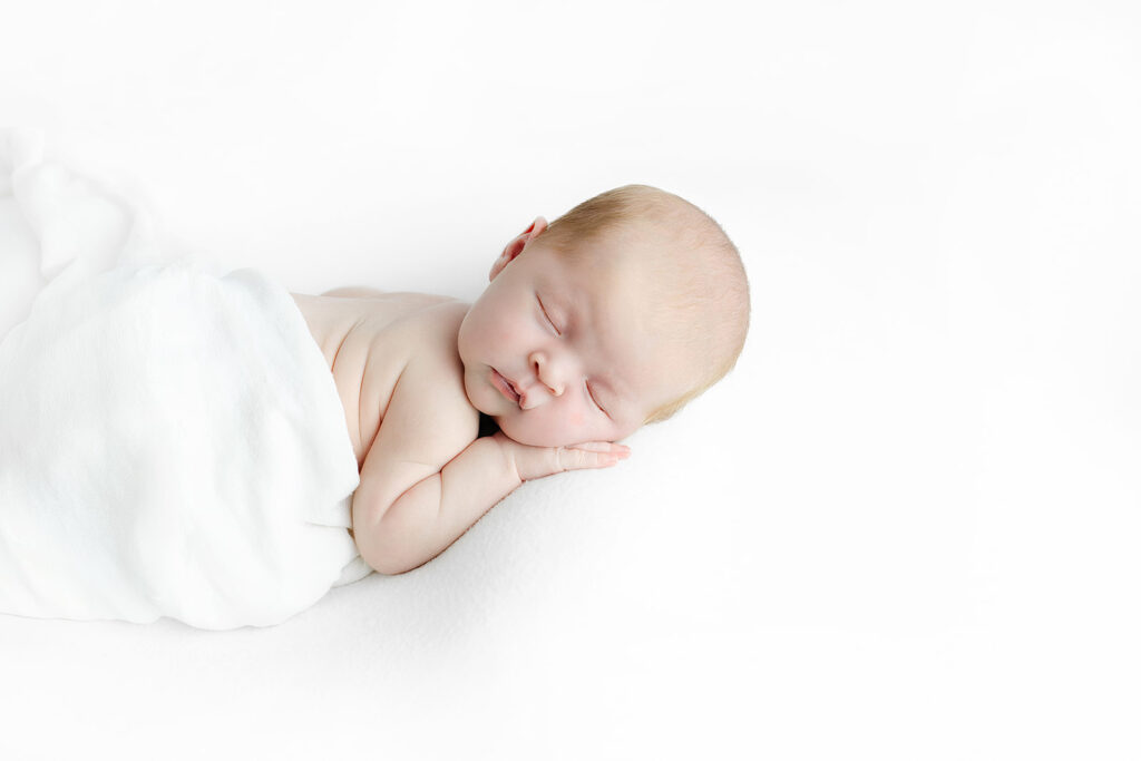 newborn baby boy sleeping peacefully with hands tucked under chin, NYC newborn photography, Heirloom by Melissa Photography