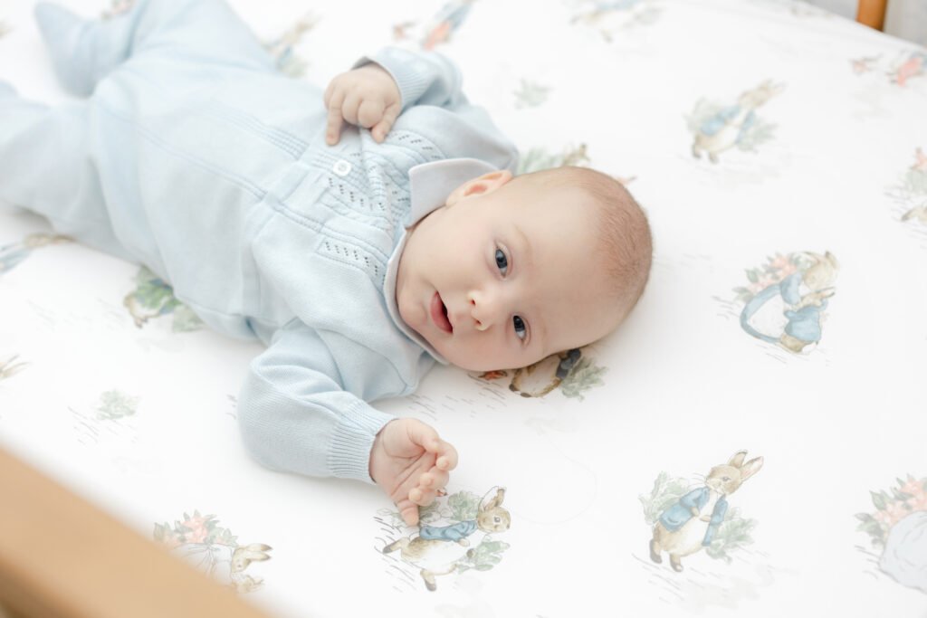 Newborn baby wearing classic Feltman Brothers outfit during in-home lifestyle session