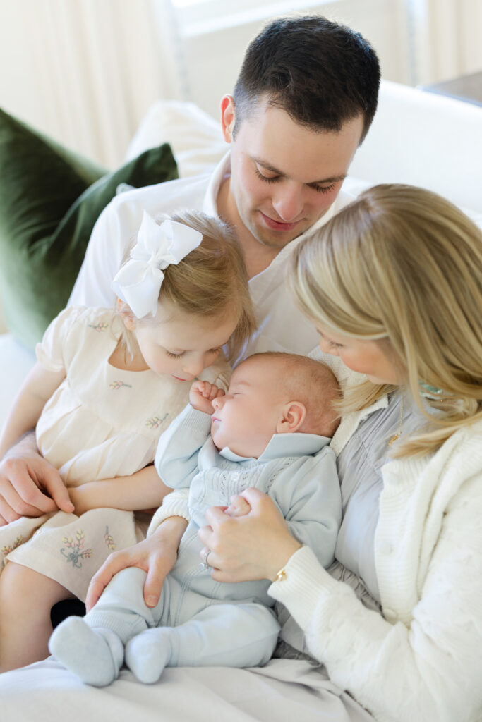Parents holding newborn baby together in bright nursery during NYC family session