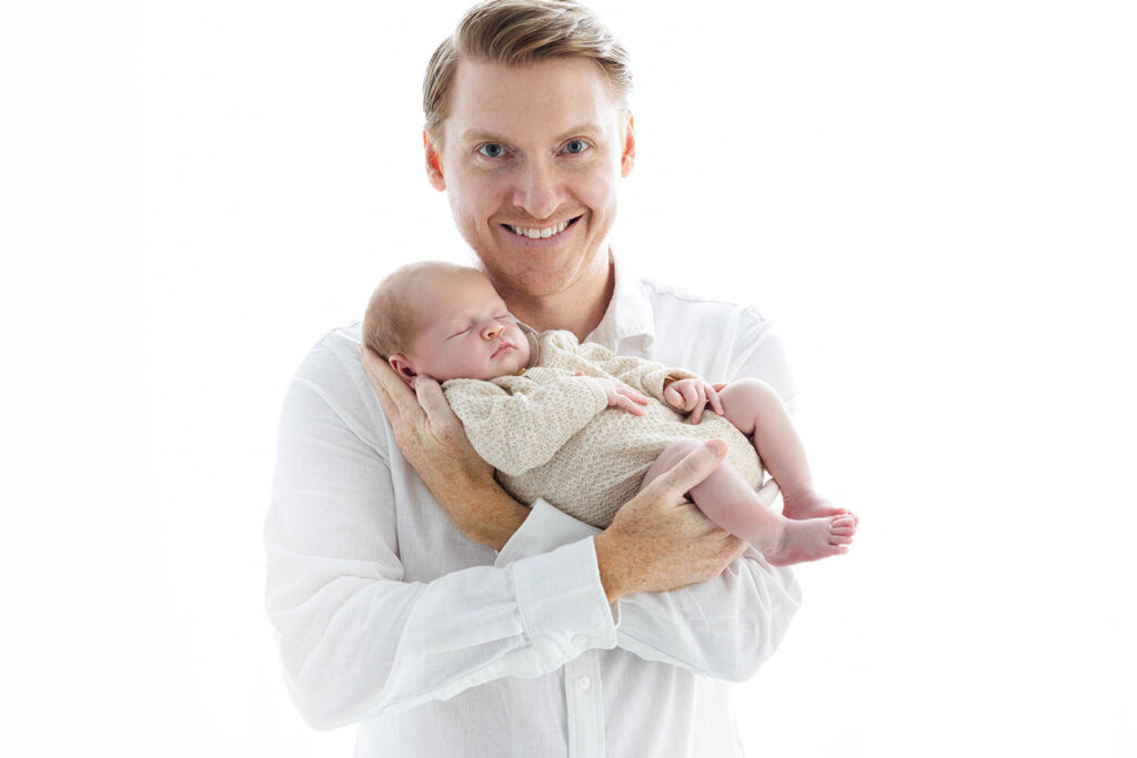 proud first time dad holding newborn baby boy on his arm, Manhattan newborn photographer, Heirloom by Melissa Photography