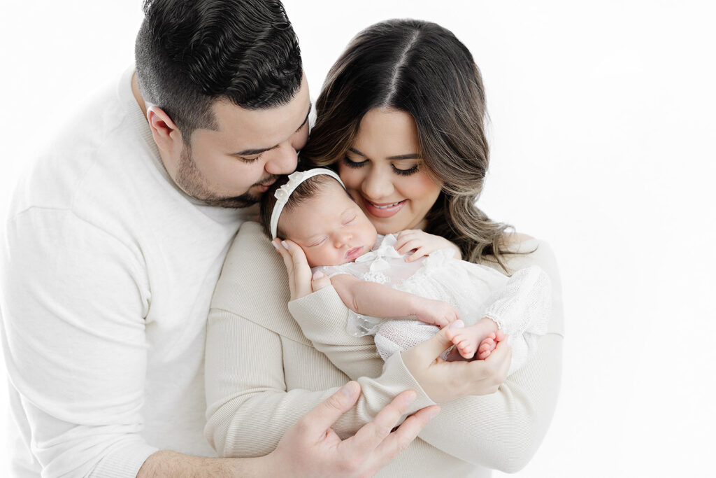 new parents smiling down at newborn baby girl, NYC newborn photography, Heirloom by Melissa Photography Manhattan