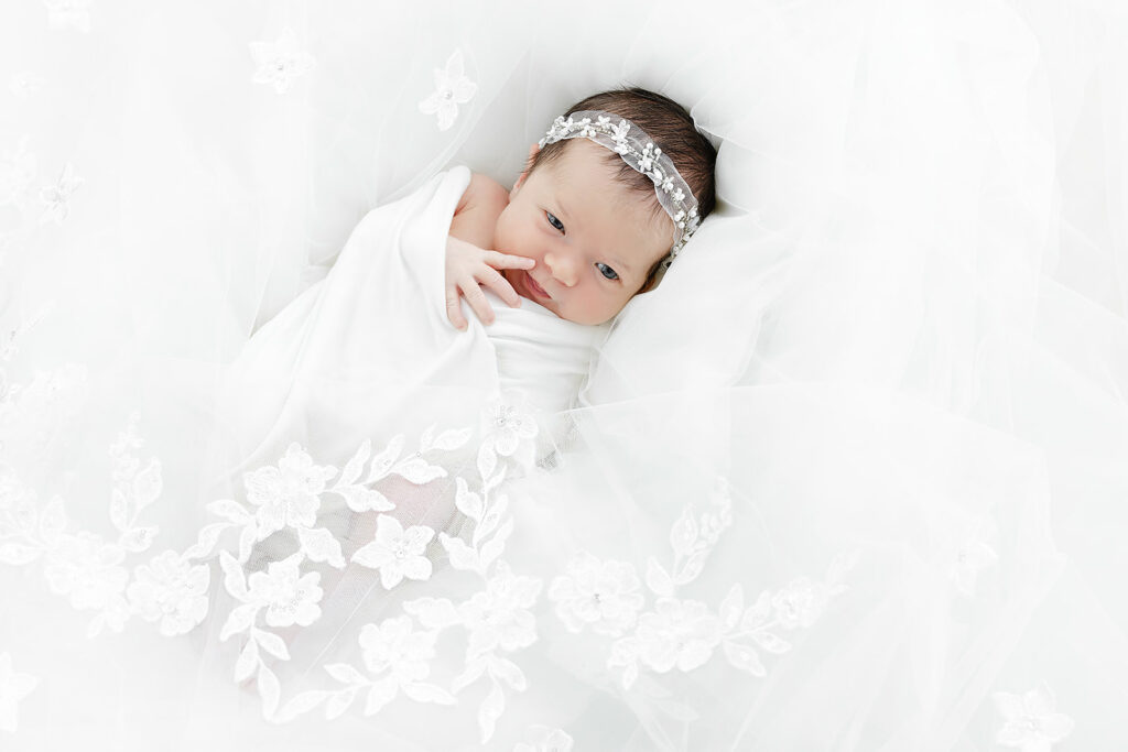 newborn baby girl smiling in sleep with polka dot bow, NYC newborn photographer, Heirloom by Melissa Flatiron studio