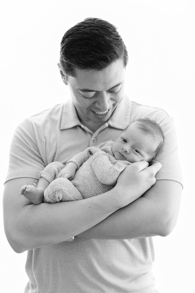 Father holding newborn baby in cream knit outfit, NYC baby photographer, Heirloom by Melissa