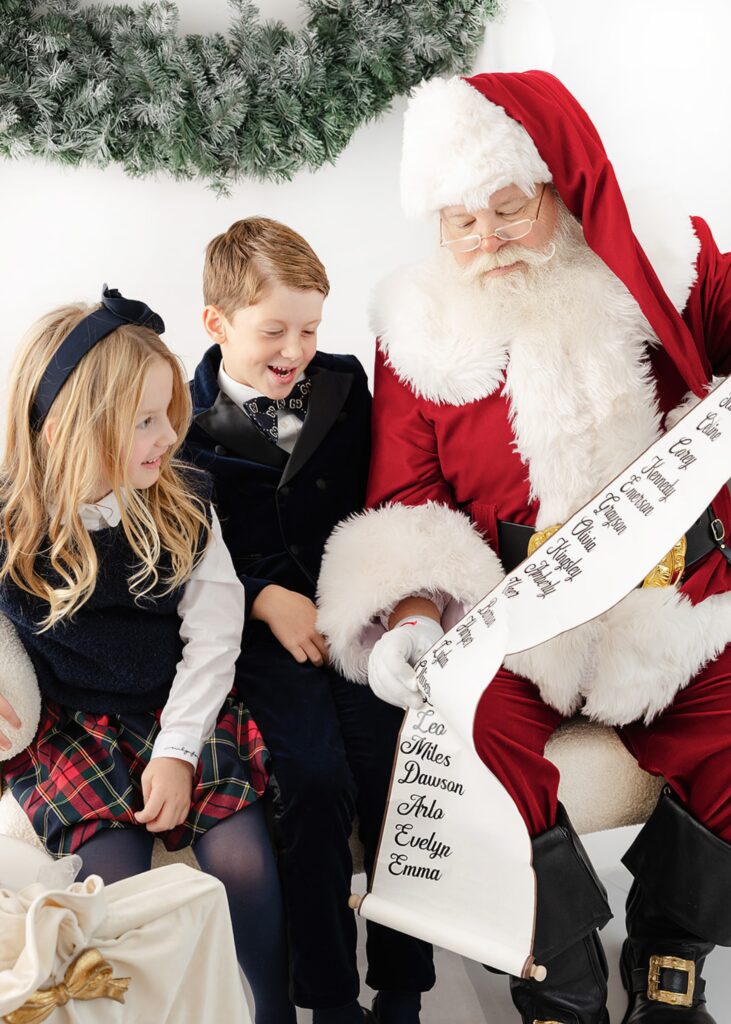 NYC Santa photos, brother and sister holding personalized gifts from Santa at Heirloom by Melissa, Flatiron District
