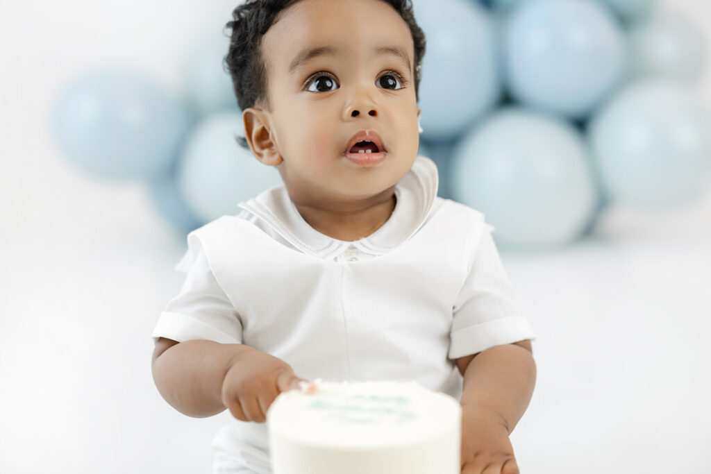 First birthday cake smash NYC, one year old reaching for his Padoca Bakery cake at Heirloom by Melissa, New York City