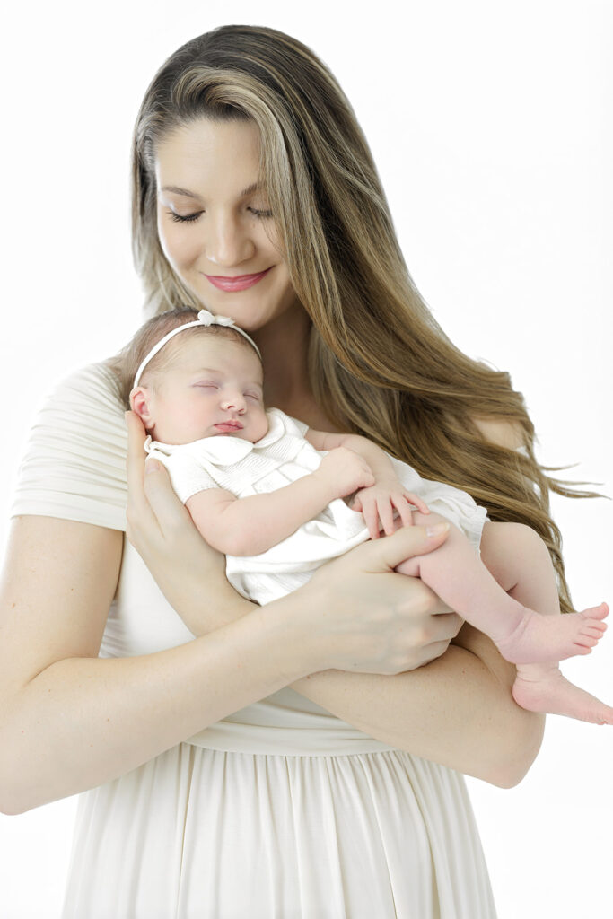 Flatiron newborn photographer, mom holding her sleeping newborn at Heirloom by Melissa, NYC
