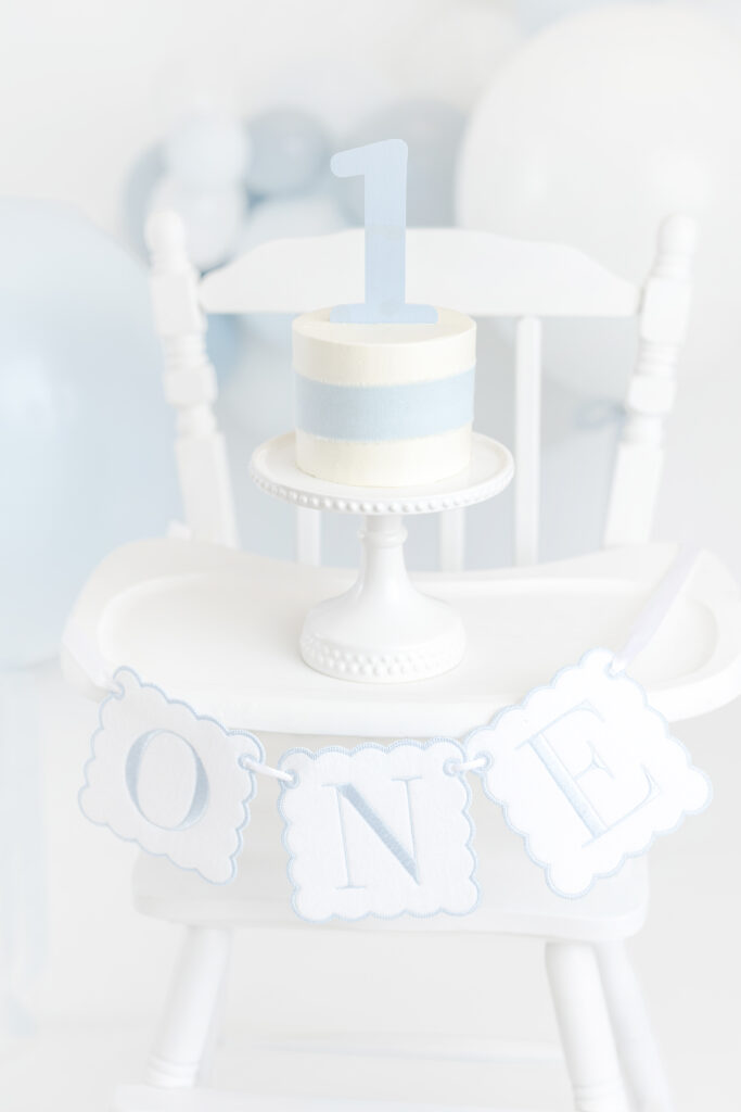 Ivory cake with light blue ribbon for NYC cake smash photos at Heirloom by Melissa, Manhattan studio