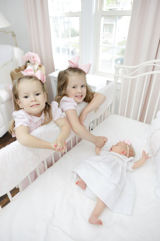  Big sisters at the crib during in-home session with New York newborn photographer Heirloom by Melissa, NYC