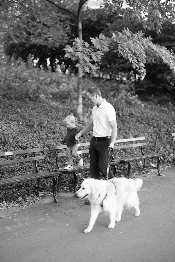 
Dad walking hand in hand with his son and their golden retriever, documented by an NYC family photographer in Central Park, Heirloom by Melissa Photography

