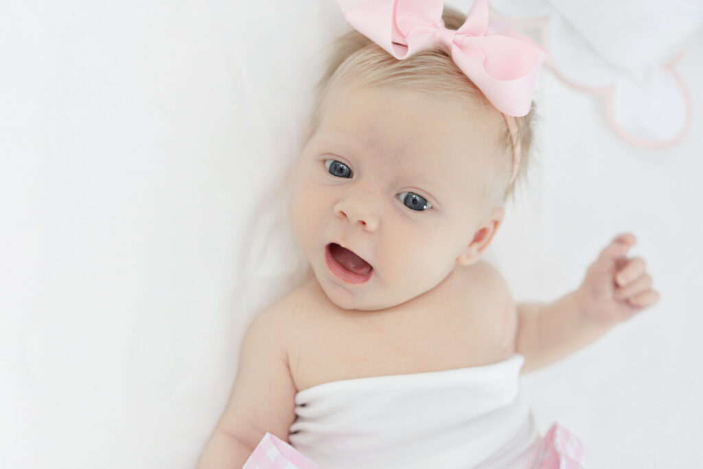 Newborn in white heirloom dress and bonnet by New York newborn photographer Heirloom by Melissa