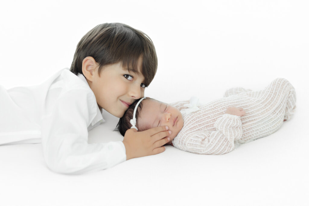 Sibling bonding - big brother with newborn baby