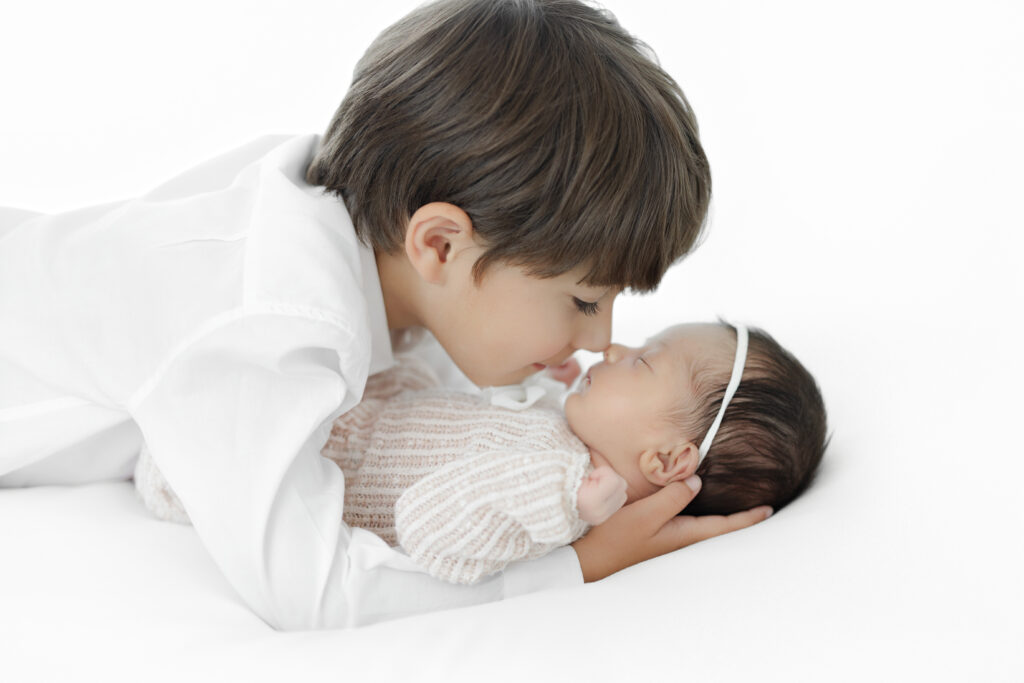 Big brother holding newborn sister - studio newborn session