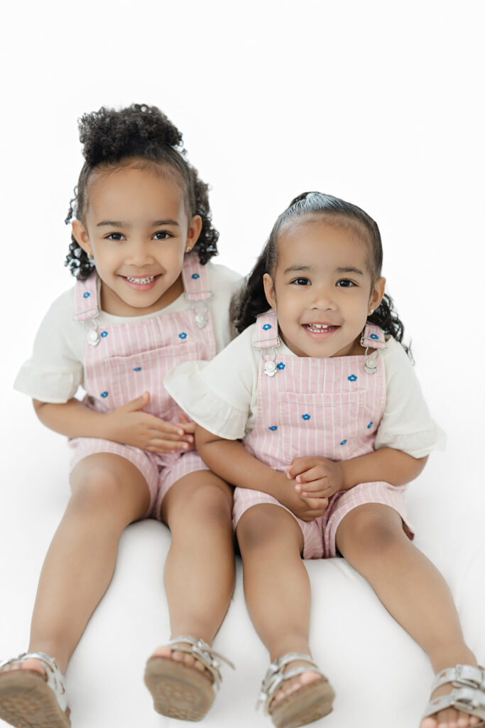 First birthday cake smash NYC, big sisters in pink overalls at Heirloom by Melissa, New York City