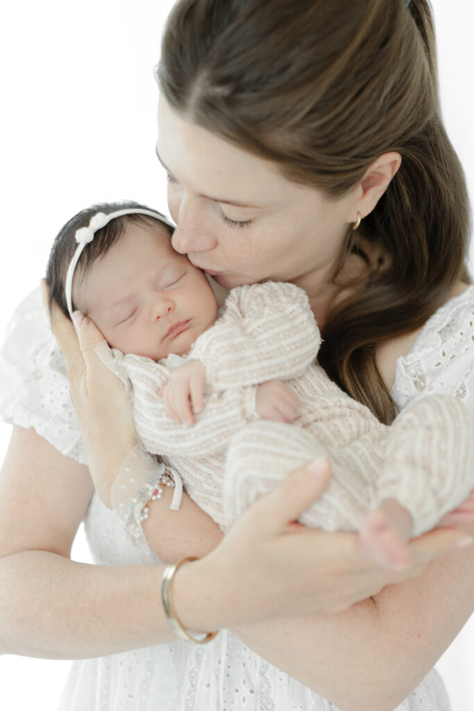 Mom kissing newborn - intimate family moment