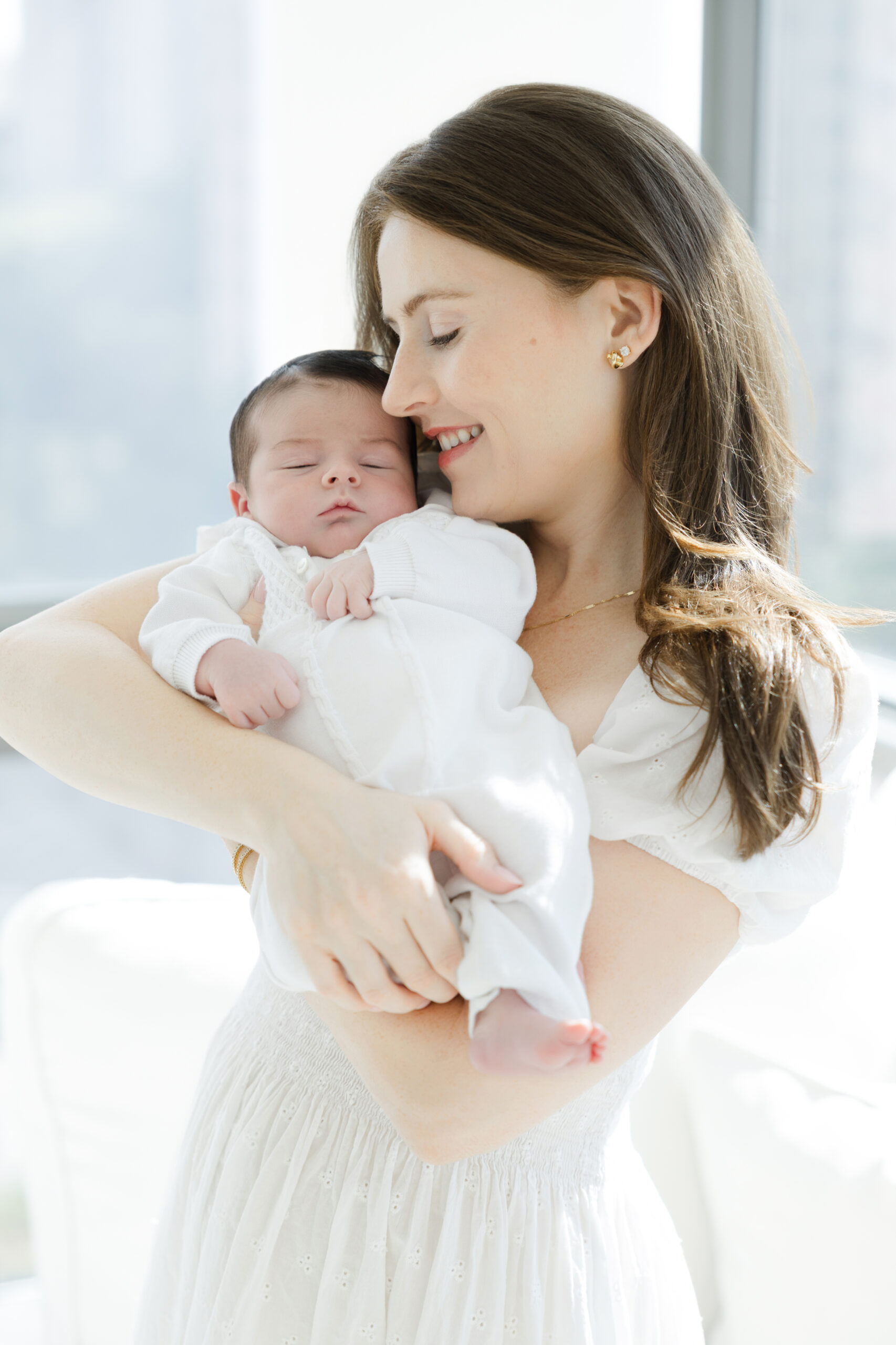 Mother holding her newborn baby during an in-home newborn session in NYC