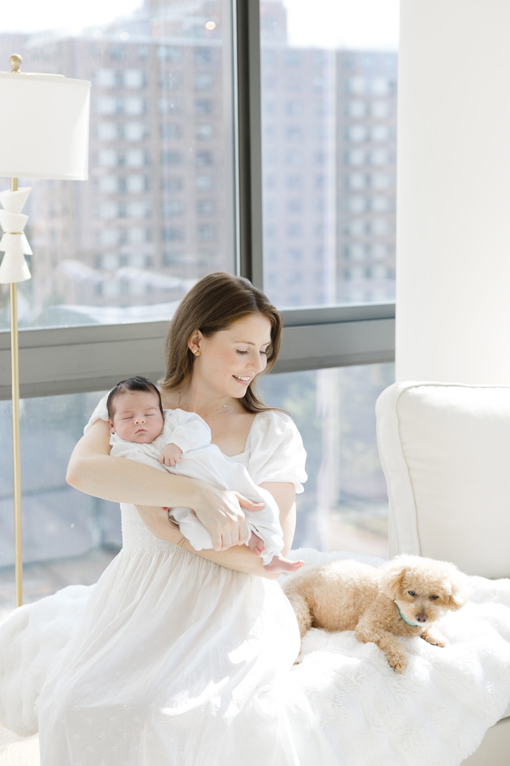 New parents with their baby in their sun-filled Manhattan apartment