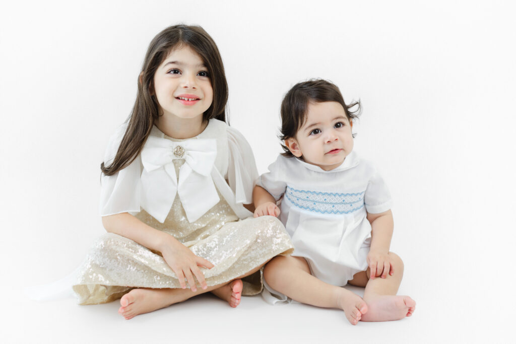Soren and his older sister sitting together for a sibling portrait