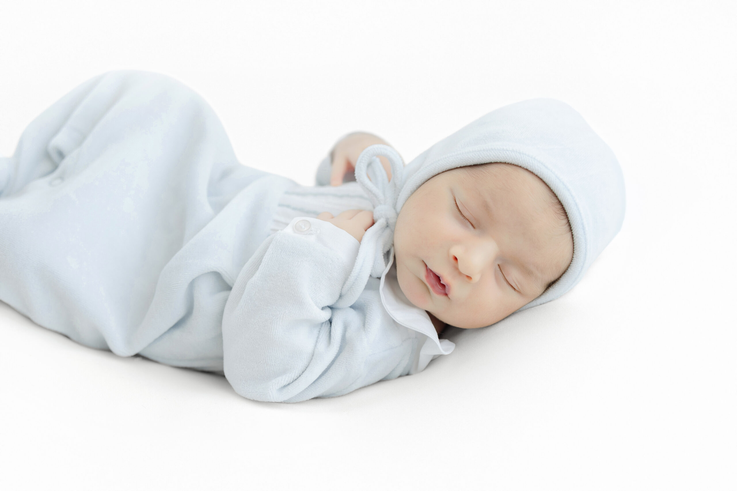 Baby boy wearing a pale blue Feltman Brothers outfit for his newborn portraits