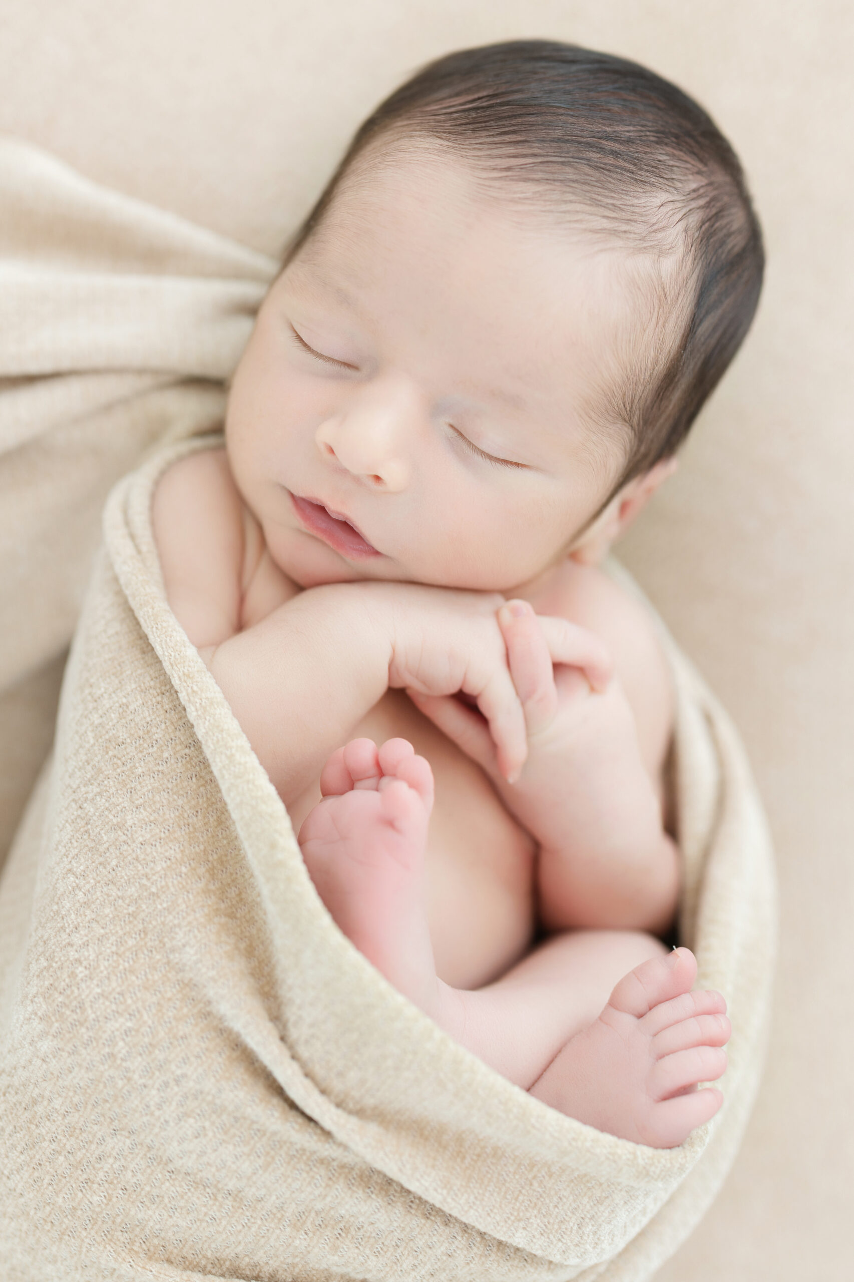Sleeping baby boy in a swaddle during his newborn session