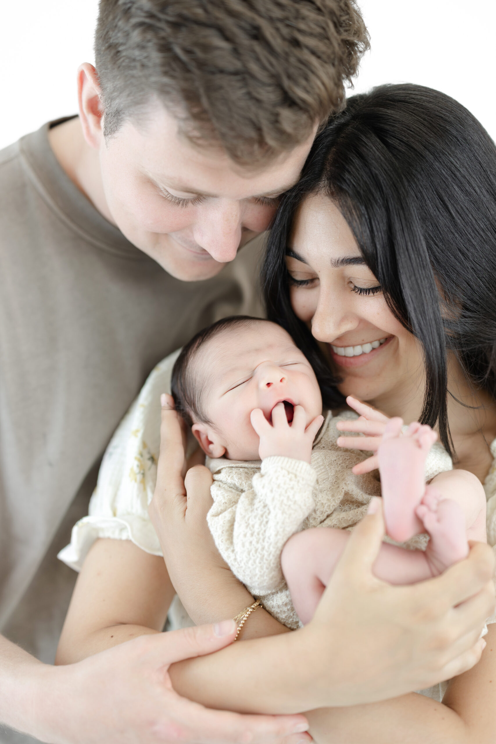 Family of three admiring their new baby during an NYC newborn photography session