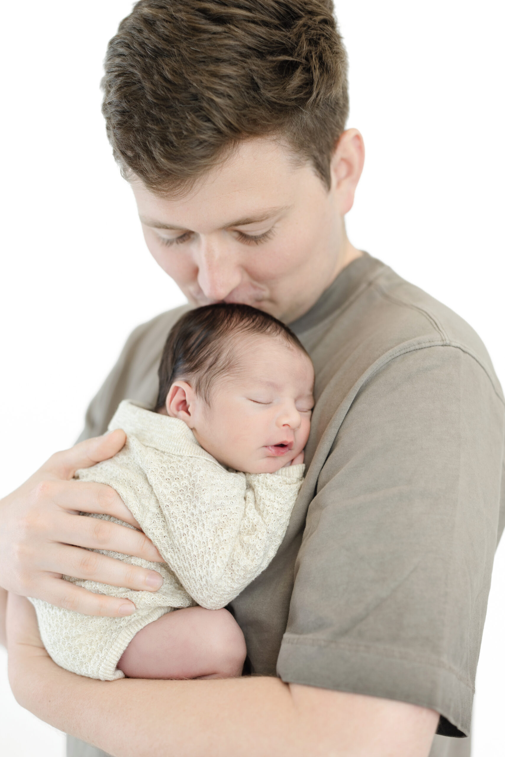 Dad kissing his sleeping newborn baby boy during a Manhattan studio session