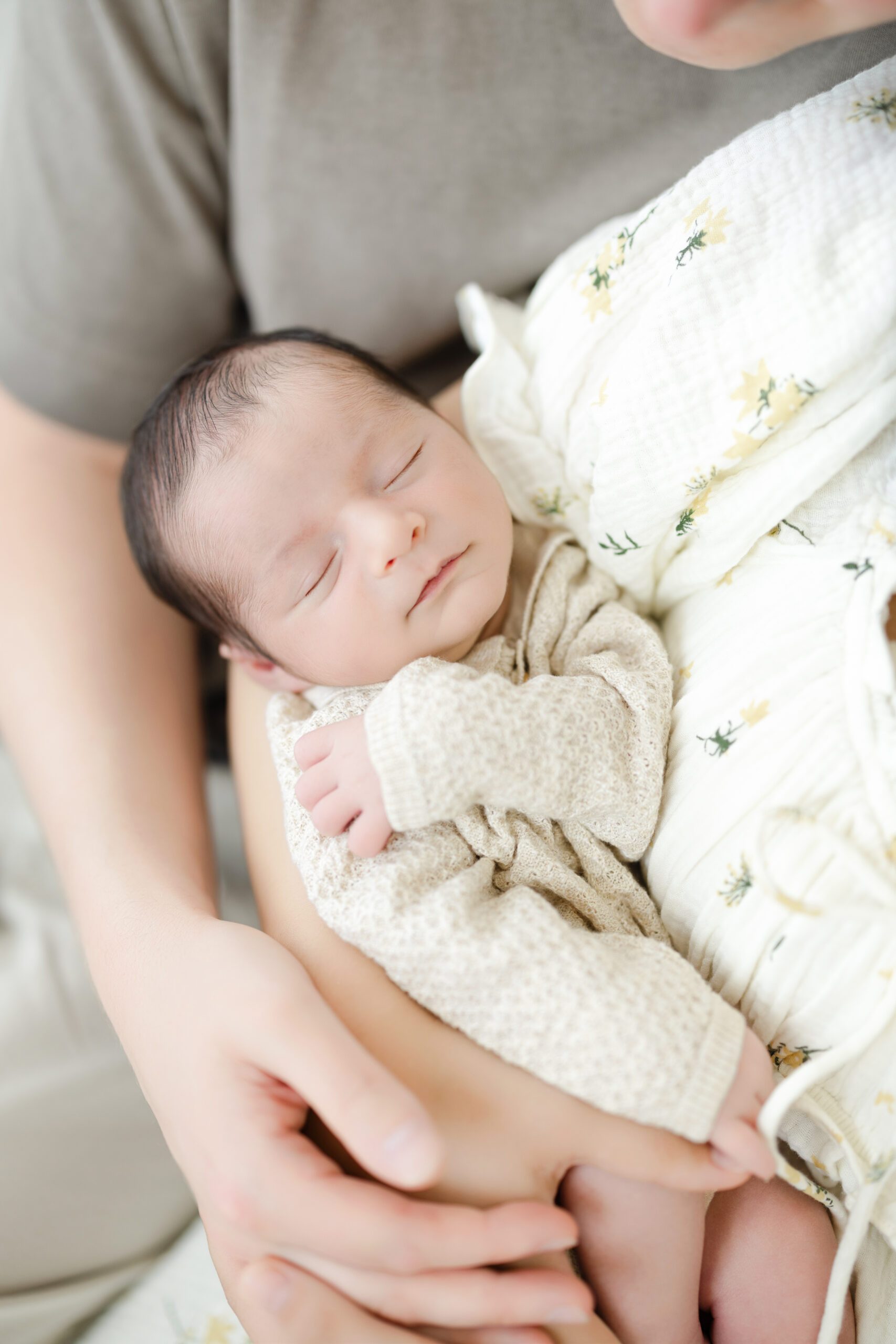 Sleeping baby boy wearing a beige Blu Caramel outfit for his newborn portraits
