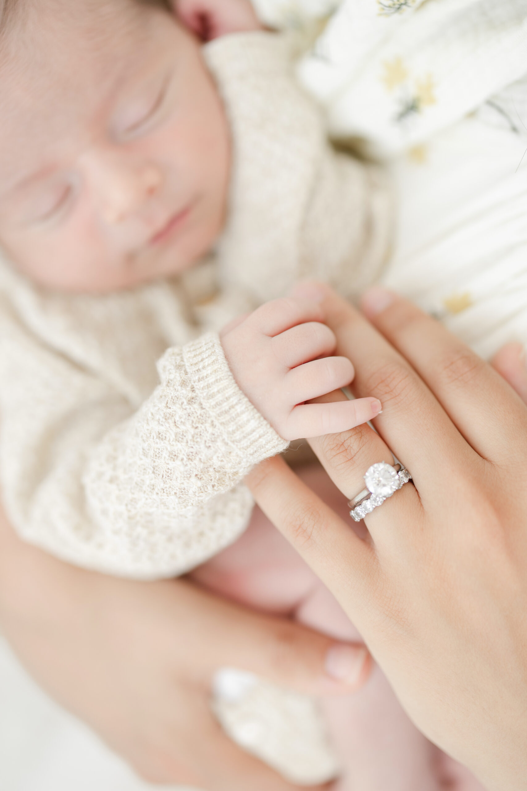 Newborn baby hand beside his mother’s ring in a meaningful detail photograph
