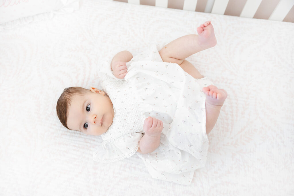 Baby girl lying in her crib during a three-month photography session in Manhattan