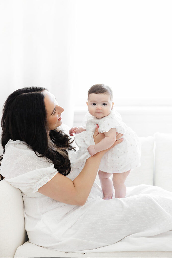 Mother playing with her baby girl during an in-home three-month session