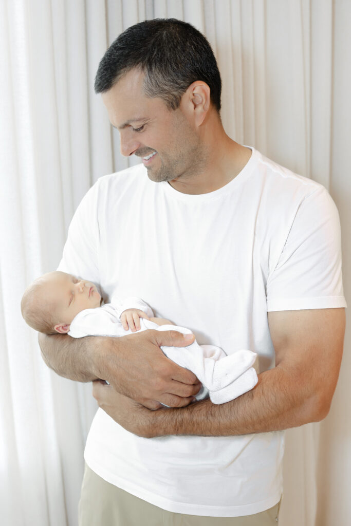 Father holding his newborn daughter in their Tribeca apartment