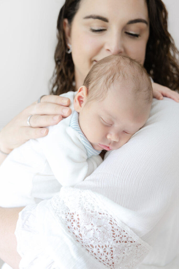 Mother holding her newborn baby during an in-home session