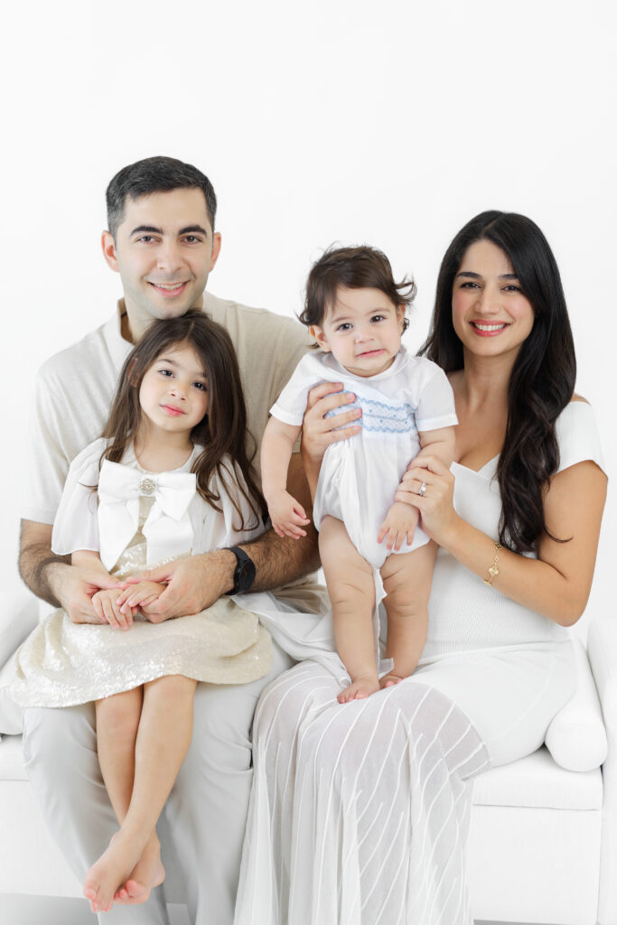 Family of four sitting together for portraits at the studio