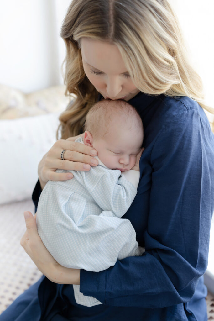 Mother sitting with her newborn and older child during an in-home session