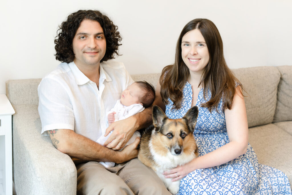 Parents standing close together with their newborn during Brooklyn in-home newborn photography