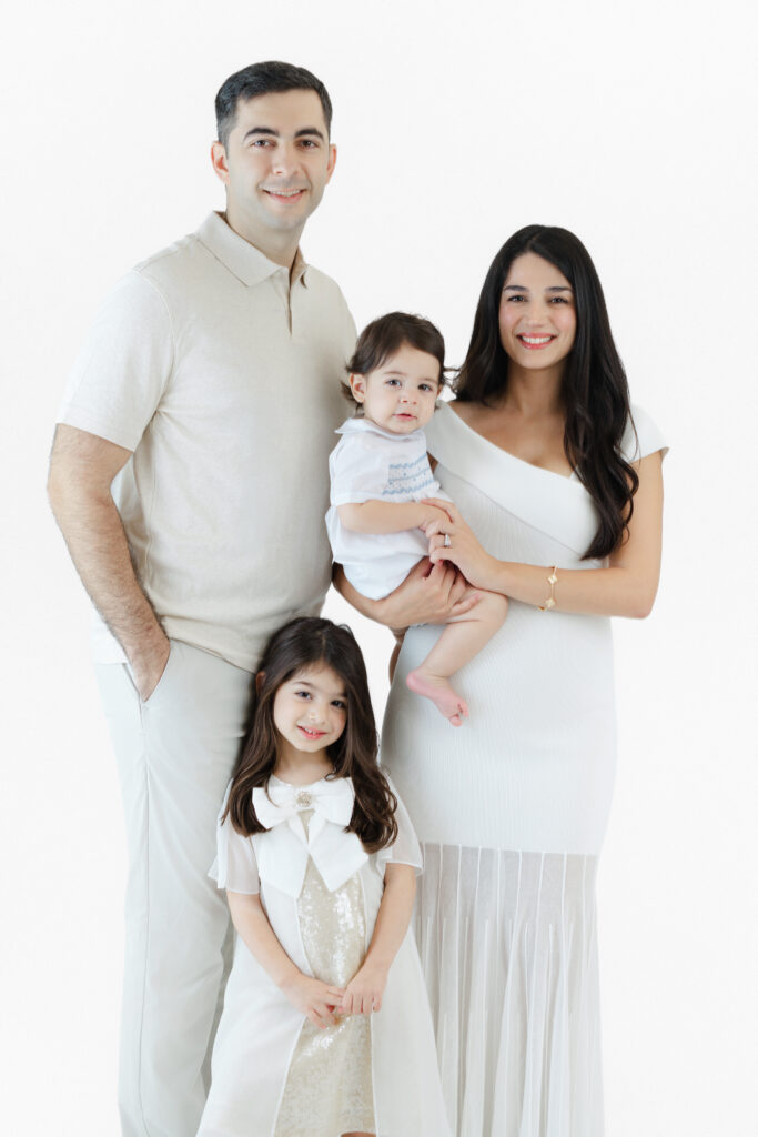 Family of four posing together during an NYC first birthday photoshoot