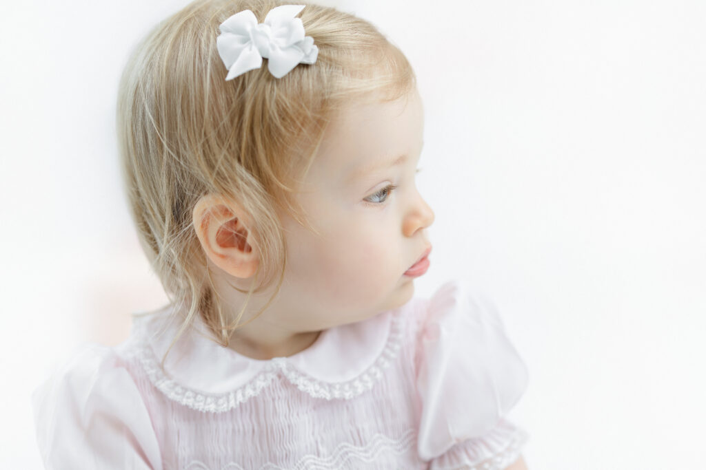 Side profile of Eleanor wearing a pale pink birthday outfit