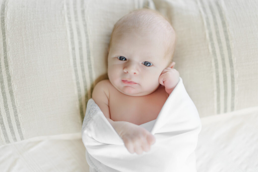Newborn baby wrapped in white for a simple portrait at home