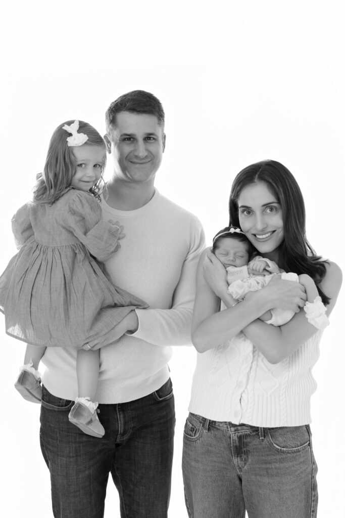 Black and white portrait of parents with their two daughters at the studio