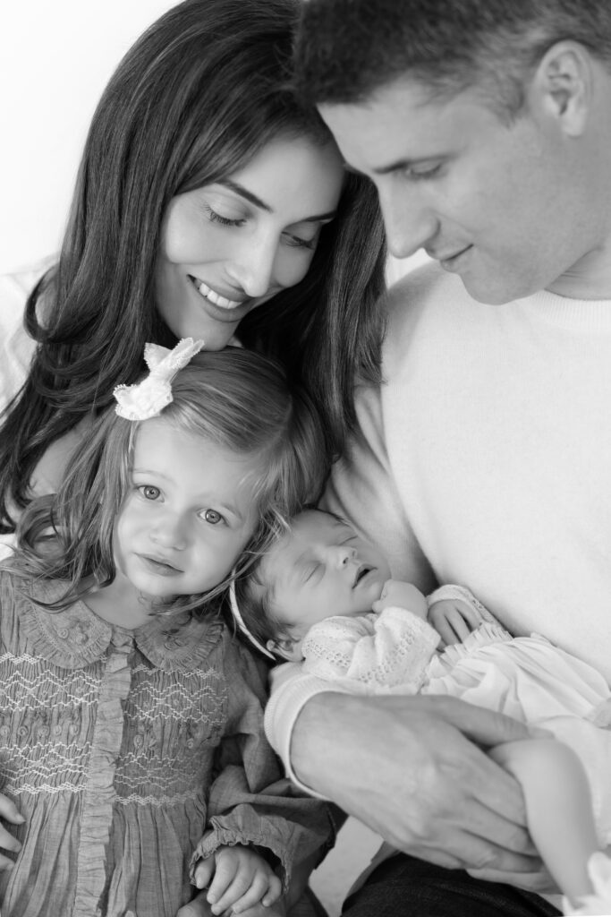 Black and white close portrait of parents with their two daughters