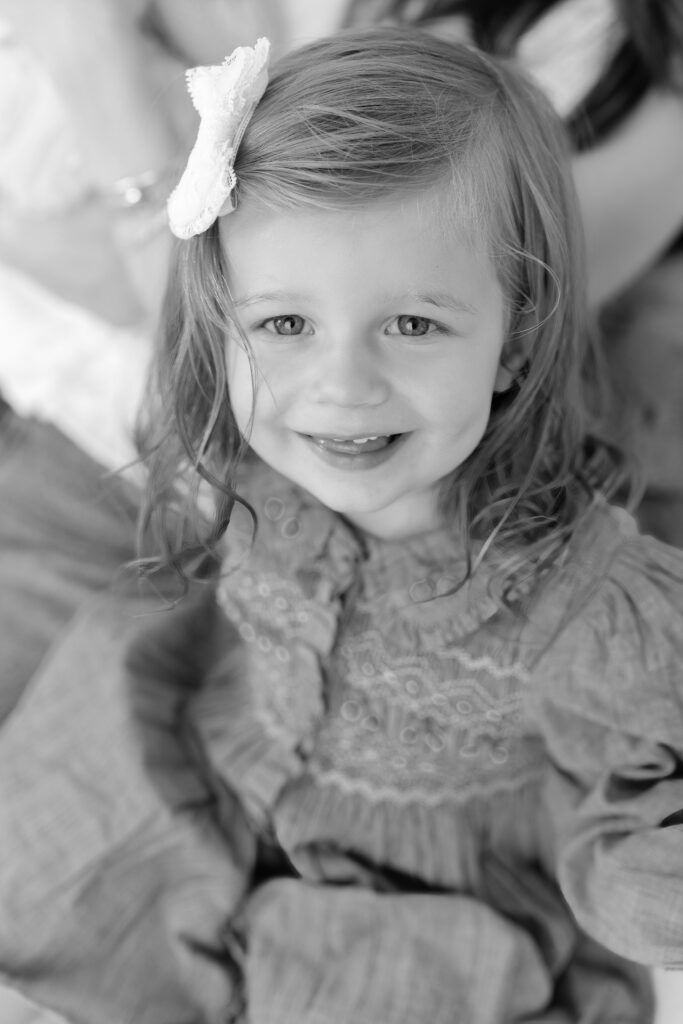 Close portrait of the older sister smiling in a blue dress