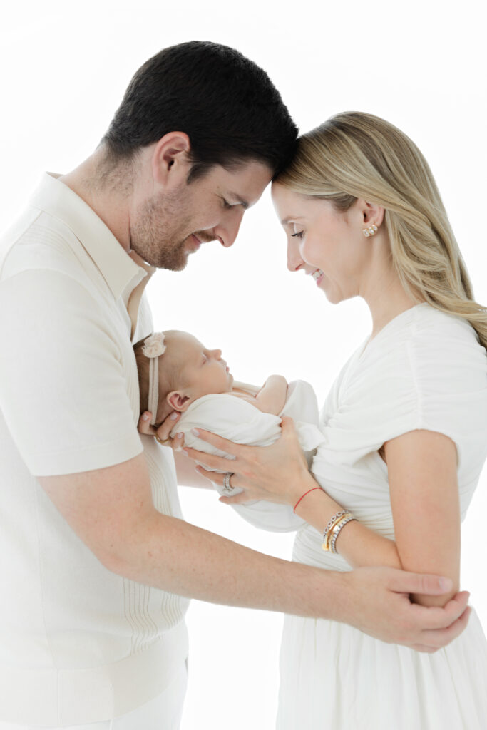Parents standing together and looking down at their newborn baby