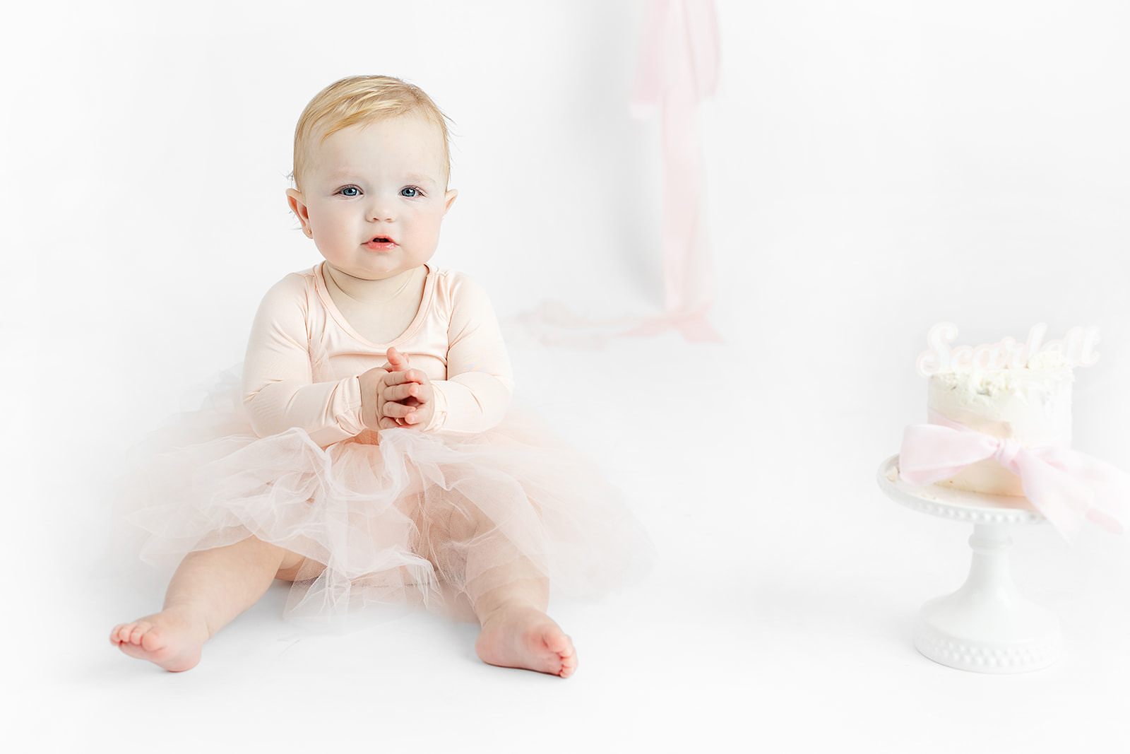 Baby girl wearing a classic white outfit for her NYC first birthday portraits
