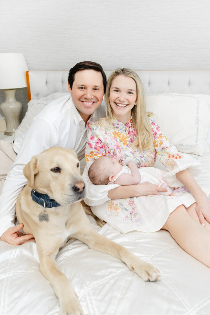 New parents, their sleeping baby, and Labrador photographed together in their Manhattan home